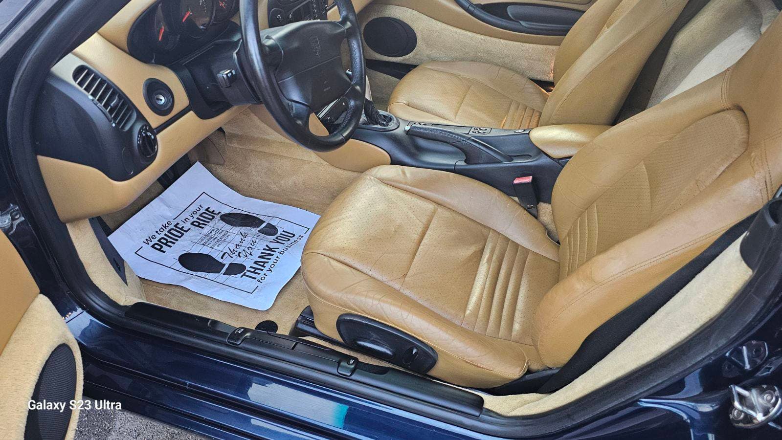 Tan leather Porsche front seats with protective floor mat detailed in Bellevue
