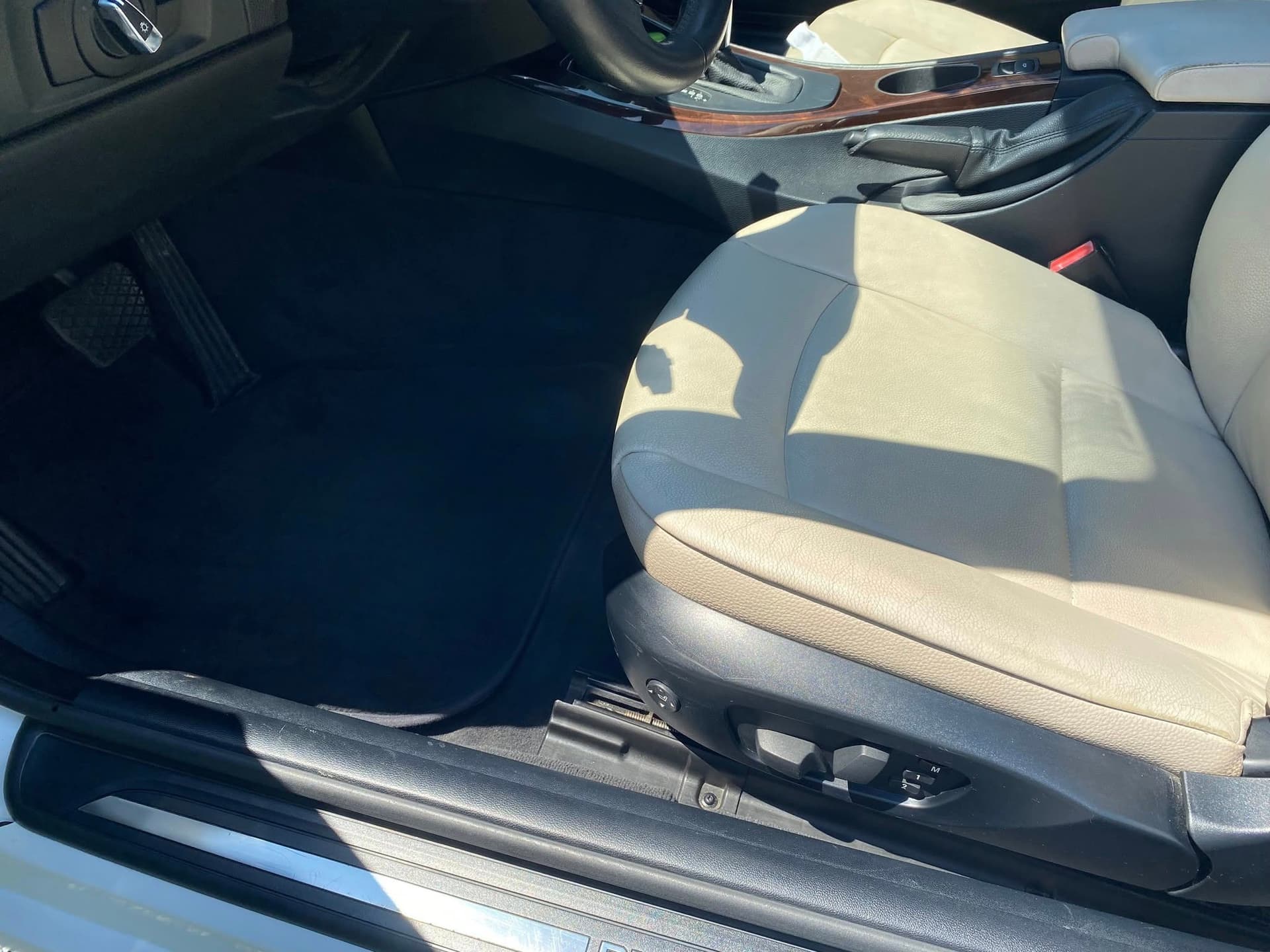 Beige leather BMW passenger seat and vacuumed black carpet in Madison