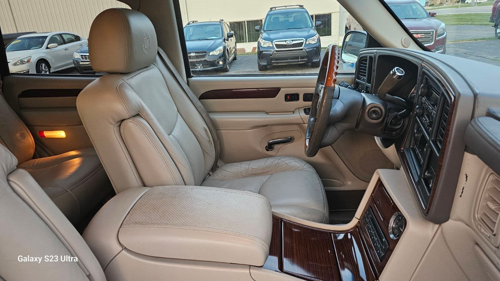 Tan perforated leather Cadillac SUV center console area detailed in Schertz