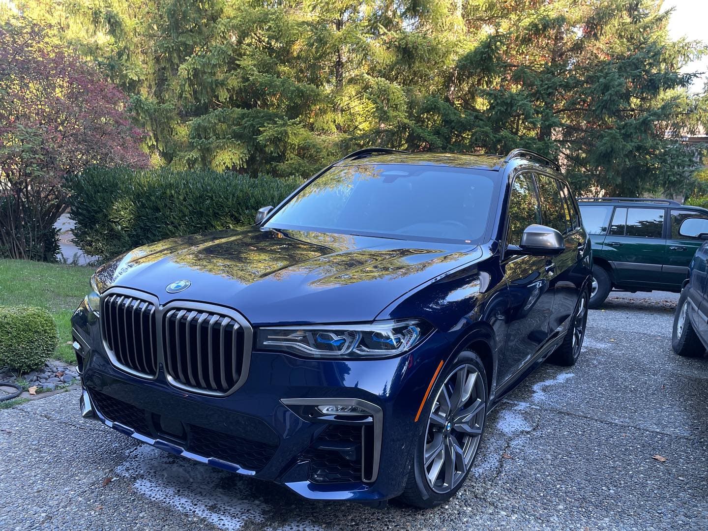 Dark blue BMW X7 SUV with mirror-like shine after mobile detailing